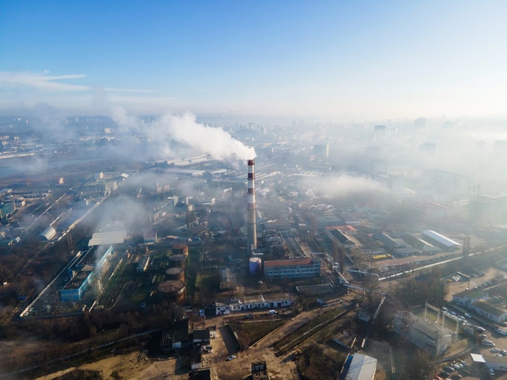 aerial-drone-view-chisinau-thermal-station-with-smoke-coming-out-tube-buildings-roads-fog-air-moldova-scaled